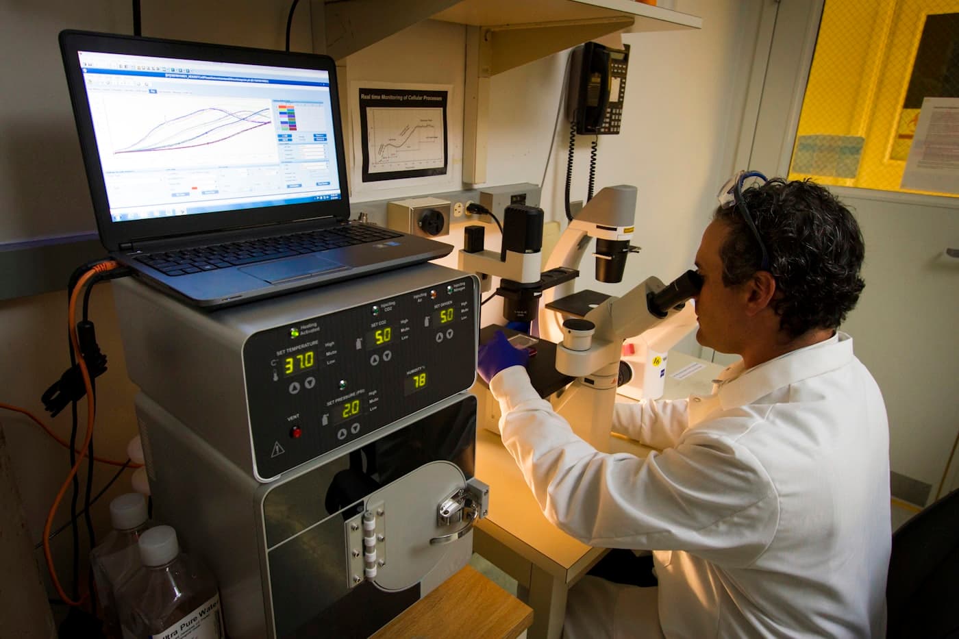 Researcher analyzing cellular process data at the microscope — the science behind target and disease biology in indication assessment