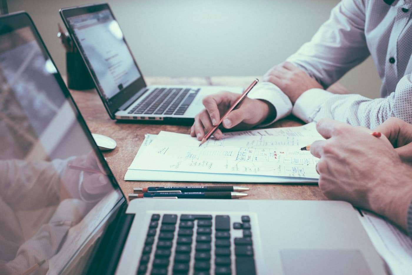 Two evaluators reviewing annotated documents and data — the hands-on work of biotech acquisition and partnership diligence